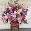 Large mixed bouquet of pink, purple, and cream flowers in a basket