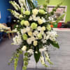 Tall white and pale green floral standing spray on an easel