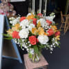 (ONE-SIDED) Orange roses accented with delicate white blooms for a bright, cheerful