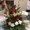 Tall red and white floral arrangement with roses, lilies, and carnations
