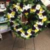 Heart-shaped floral wreath with white, yellow, and dark purple flowers