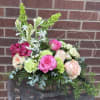 Mixed bouquet in a glass vase with pink, peach, white, and green flowers