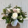Roses, hyacinth, scabiosa, waxflower in a white vase