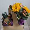 Sunflower bouquet with berries and a coffee cup in a gift box