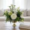 White and green floral arrangement in a gold pedestal vase