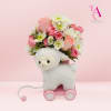 Pink and white flower arrangement with a plush lamb on a small pink cart