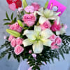 Pink roses and white lilies in a bouquet with an "I LOVE YOU" pick