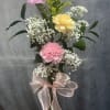 Pink and yellow carnations with white baby's breath in a glass vase