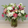 Mixed pink and white flowers arranged in a glass vase