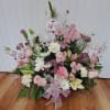 Pink and white mixed flower arrangement in a basket with a ribbon