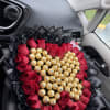 Heart-shaped bouquet of red roses and gold chocolates wrapped in black paper