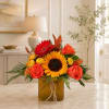 Sunflower and rose arrangement in a square amber vase
