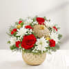Red and white floral arrangement in a gold ornament-shaped vase