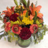 This gorgeous centerpiece is dripping with seasonal charm! Featuring orange lilies, burgundy