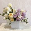 Lavender roses and creamy white blooms mingle in a soft, pastel presentation