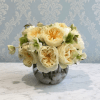 This arrangement is the definition of understated luxury. Featuring creamy ivory garden