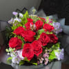 Bouquet of red roses with pale lavender flowers and black wrapping