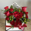 Red roses arranged in a black-and-white gift box with a red ribbon