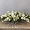 Low white floral arrangement in a decorative silver bowl