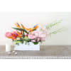 Tropical flower arrangement in a white rectangular box with pink roses