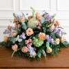 Large pastel floral arrangement with peach roses, lavender blooms, and green hydrangeas