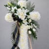 White floral standing spray with lilies and roses on an easel