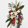 Standing floral spray with red and white flowers and ribbon on a black easel