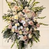 Large standing floral spray with pale roses and orchids on an easel