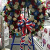 Large floral wreath with red, white, and blue flowers on an easel