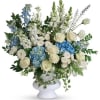 White and blue floral arrangement in a white pedestal vase