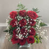 Red roses with baby's breath in a clear glass vase