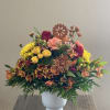 Mixed bouquet in a white vase with yellow, pink, and burgundy flowers