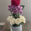 Red and white roses arranged in a glittery glass vase