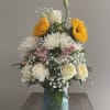 Mixed bouquet in a blue glass vase with white, pink, and yellow flowers