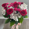 Bouquet of pink roses and white alstroemeria in a glass vase