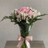 Pink and white bouquet in a clear glass vase with a pink ribbon