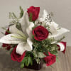 Bouquet of red roses and white lilies in a dark vase