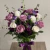 Pink and white roses with purple flowers in a glass vase