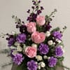 Pink roses and purple carnations in a green vase