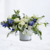 White and blue floral arrangement in a clear glass vase