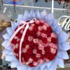 Large bouquet of red and pink roses wrapped in pale blue paper