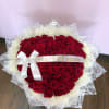 Large bouquet of red roses wrapped in white paper with a ribbon