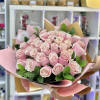 Large hand-tied bouquet of light pink roses wrapped in pink and tan paper