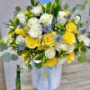 Hatbox arrangement of yellow and white roses with mums, blue thistles, and an It’s a Boy pick.