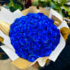 Large bouquet of vivid blue roses wrapped in white and gold paper