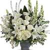 White lilies and roses arranged in a gray urn vase