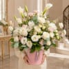Large bouquet of white roses, lilies, and pink carnations in a pink box