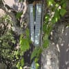 Gray memorial wind chime hanging from a tree with floral accents