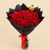 Bouquet of red roses wrapped in black paper with a red ribbon