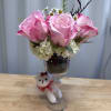 Pink roses and white hydrangeas in a wine glass with a small teddy bear